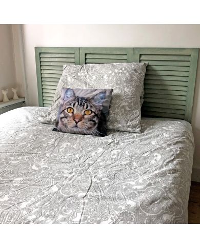 Gezellige slaapkamer met een upcycled witte shutter - hoofdbord, geaccentueerd door een kussen met kattengezicht.