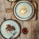A rustic wooden table features two bohemian dinner plates.