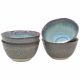 Four ceramic ramen bowls in a gradient of blue and grey, stacked and one tilted to reveal its interior.