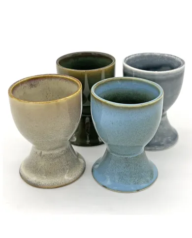Four assorted ceramic egg cups with a reactive glaze finish.