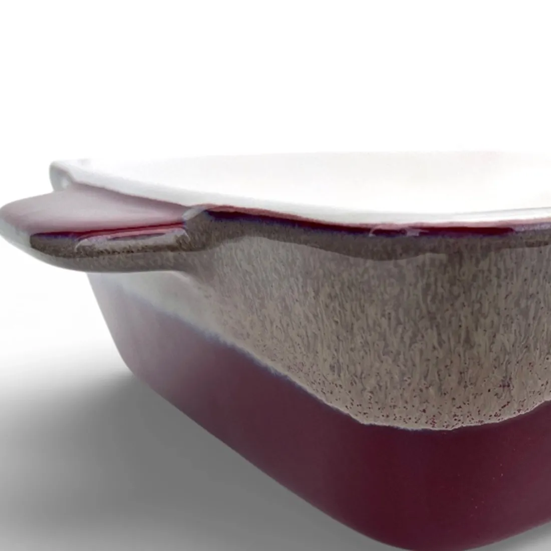 Een close-up van een reactief geglazuurde ovenschaal met een glanzend witte binnenkant.