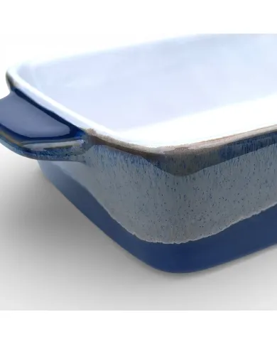 A close-up of an oven dish featuring a smooth white interior and a reactive glaze exterior.