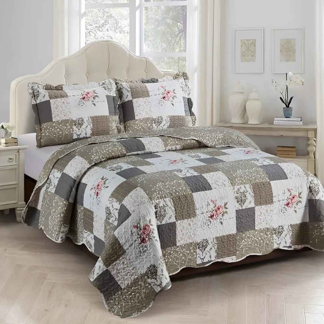 Bedsprei beige patchwork met bloemmotief op een bed in een lichte gedecoreerde kamer.