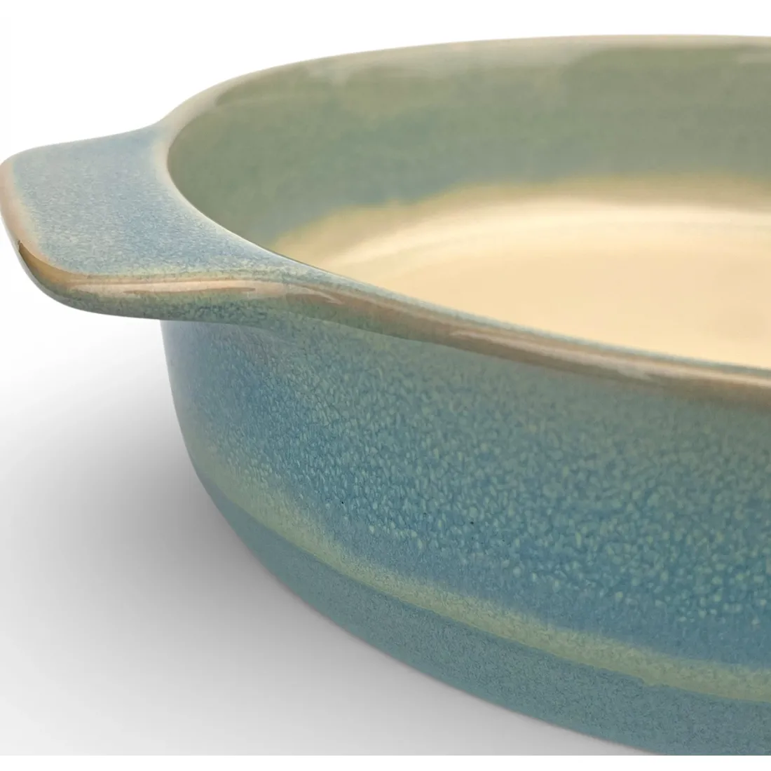 Een close-up van een ronde ovenschaal waarbij de reactieve glazuurafwerking goed tot zijn recht komt.