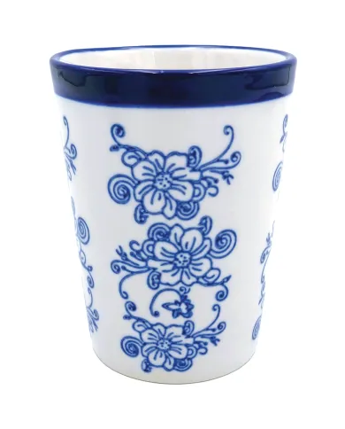A decorative tall ceramic mug featuring blue floral designs on a white background and a blue rim.
