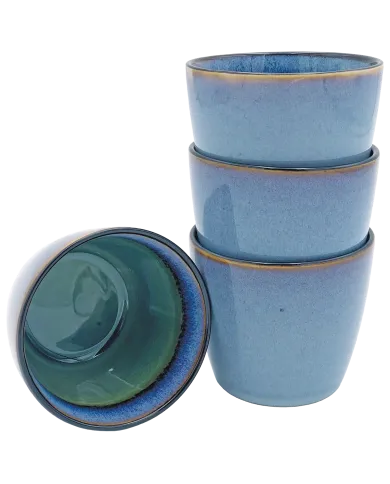Blue cappuccino mugs stacked with one inverted to show green interior.