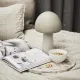 A dessert bowl with nuts sits on a marble tray beside a mushroom lamp.