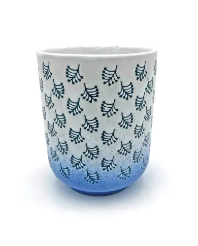 Close-up van een mok uit de witte & blauwe beker set met donkerblauwe bladmotieven en een blauw kleurverloop aan de onderkant.