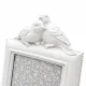 Close up of decorative birds on top of a white photo frame.