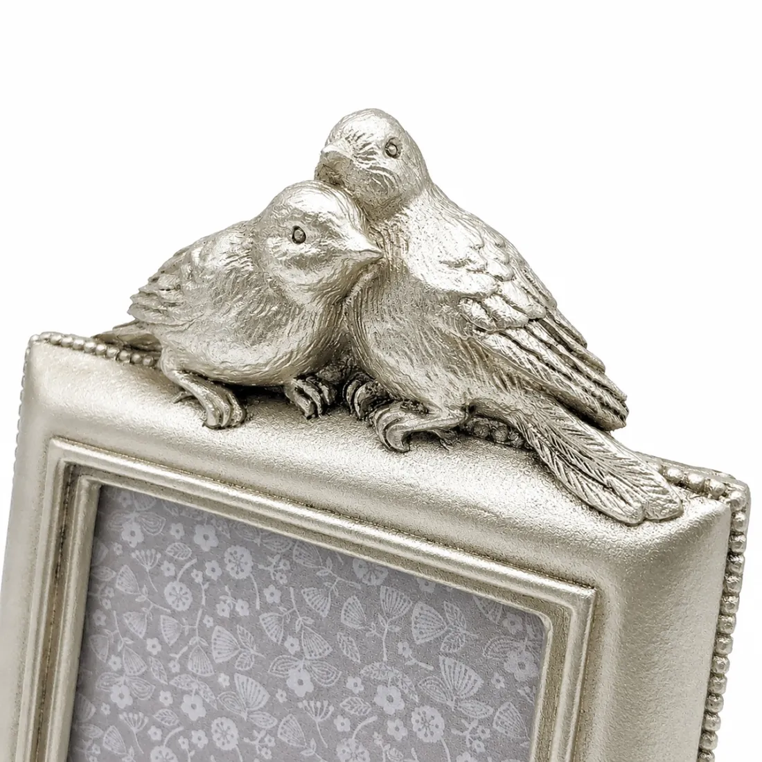 Close-up van decoratieve vogeltjes bovenop een fotolijst met lovebirds.