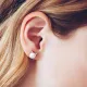 Close-up of an ear wearing cat stud earrings with a pearl and small silver cat ears.
