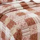 Close-up van een roze bedsprei met een symfonie van gedempt roze en cranberry vlakken.