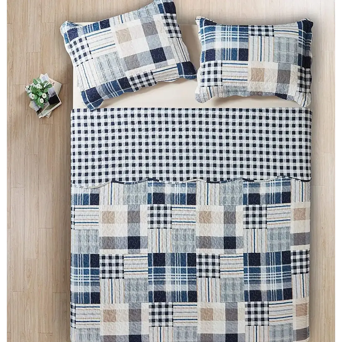 Bovenaanzicht van een blauwe bedsprei op een bed, aangevuld met bijpassende sierkussens.
