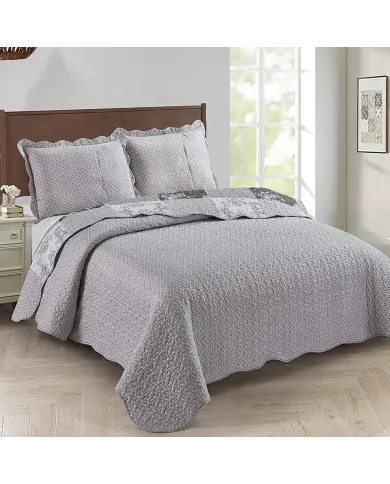 Showcasing the Toile de Jouy patchwork design of the grey quilt, paired with matching pillows.