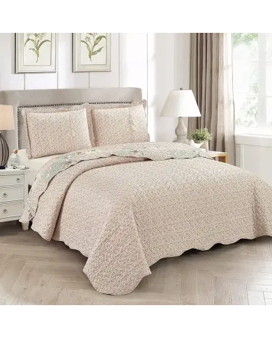 Showcasing the reverse design of the floral bedspread, a delicate rosebud print, paired with matching pillows.