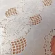Close up detail of a white table runner made from vinyl with lace details.