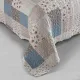 Detail van een bed sprei bloemen motief met blauw en wit patchwork, vermicellistiksels en geschulpte randen.