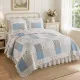 Cozy bedroom featuring a floral bedspread in a patchwork cottage look, complemented by matching pillows.