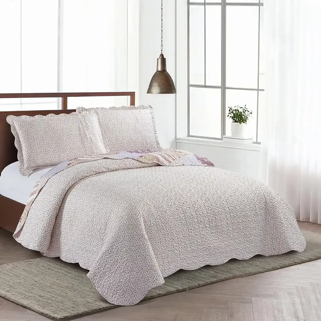 Showcasing the reverse design of Meadow Flowers quilt, delicate rosebuds on a cream background, paired with matching pillows.