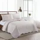 Het omgekeerde ontwerp van een bedsprei oud roze met delicate rozenknoppen op een crèmekleurige achtergrond.