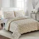 Showcasing the reverse design of the Spring Floral quilt, a small pink rose print, paired with matching pillows.