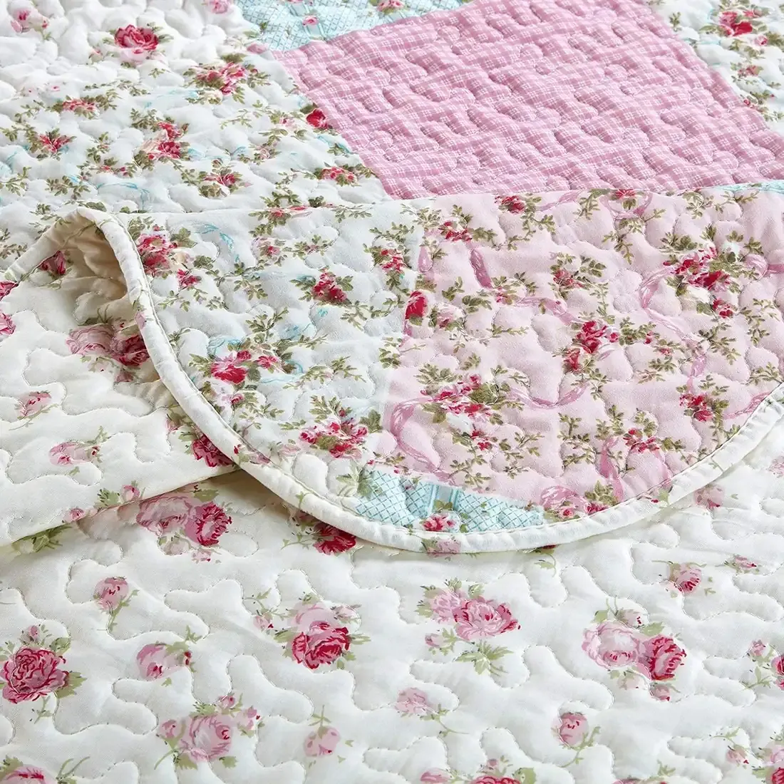 Close-up of a pink quilt, showcasing pink patchwork with a delicate stitching texture.