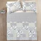 Top view of a patchwork blue quilt on a bed, complemented by matching decorative pillows.