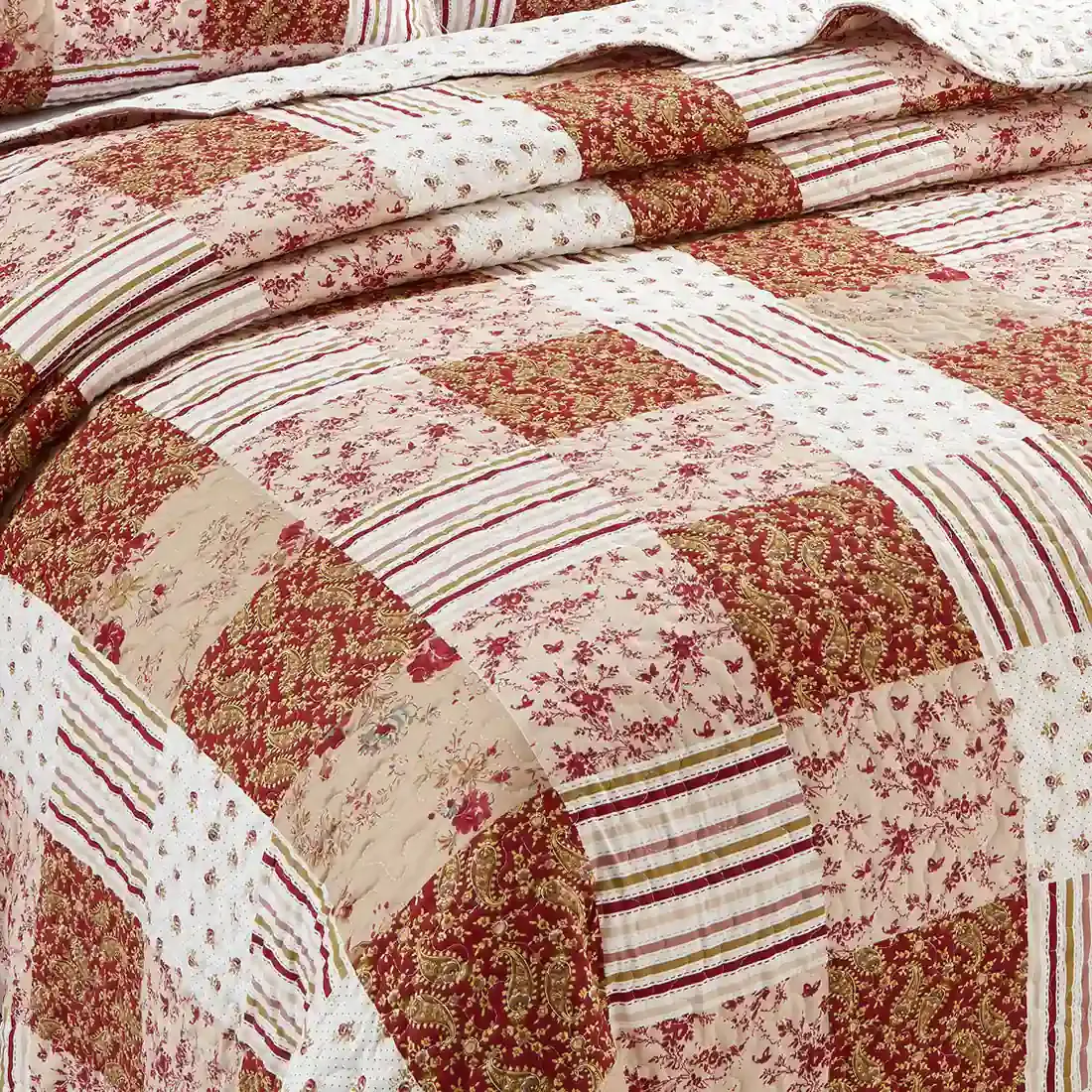 Close-up of a quilt, showcasing a symphony of muted pinks and cranberry tiles.