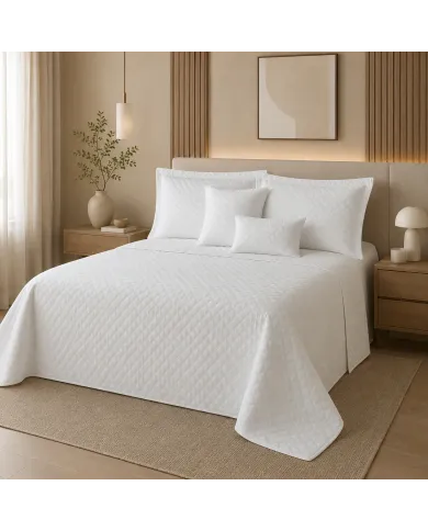 Rustgevende slaapkamer met een bedsprei wit en bijpassend beddengoed in natuurlijk licht.
