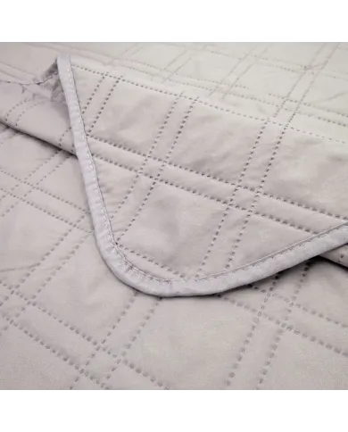 Close-up of a grey bedspread with a delicate stitching texture.