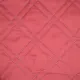 Close-up of a red bedspread showcasing a double diamond pattern.