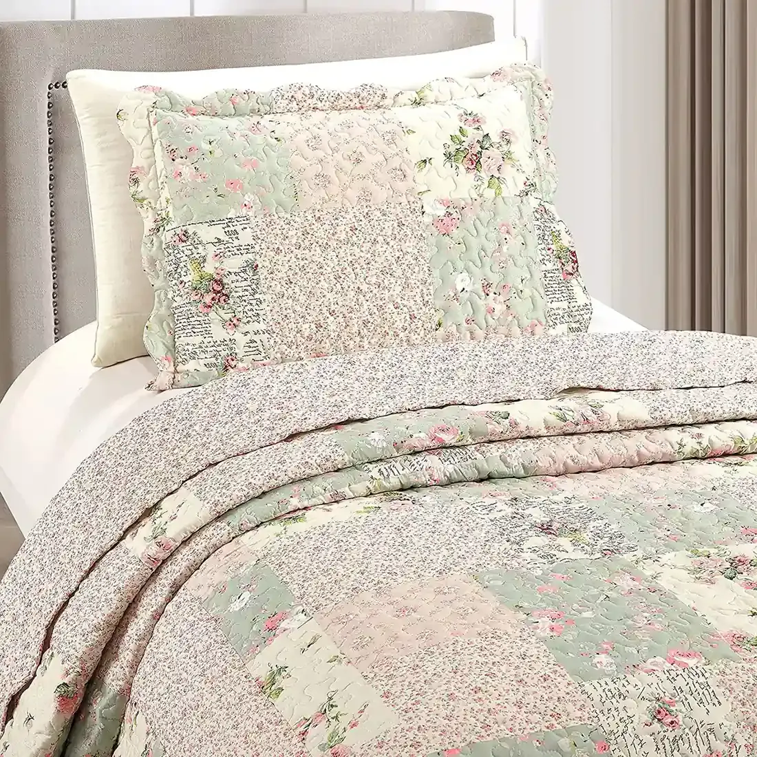 Een kussensloop groen en roze met bijpassende sprei op een knus bed bij het raam.