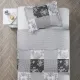Bovenaanzicht van een grijze kussensloop op een bed, aangevuld met een bijpassende patchwork sprei.