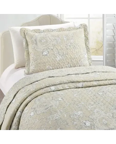 Een beige kussensloop met bijpassende sprei op een knus bed bij het raam.