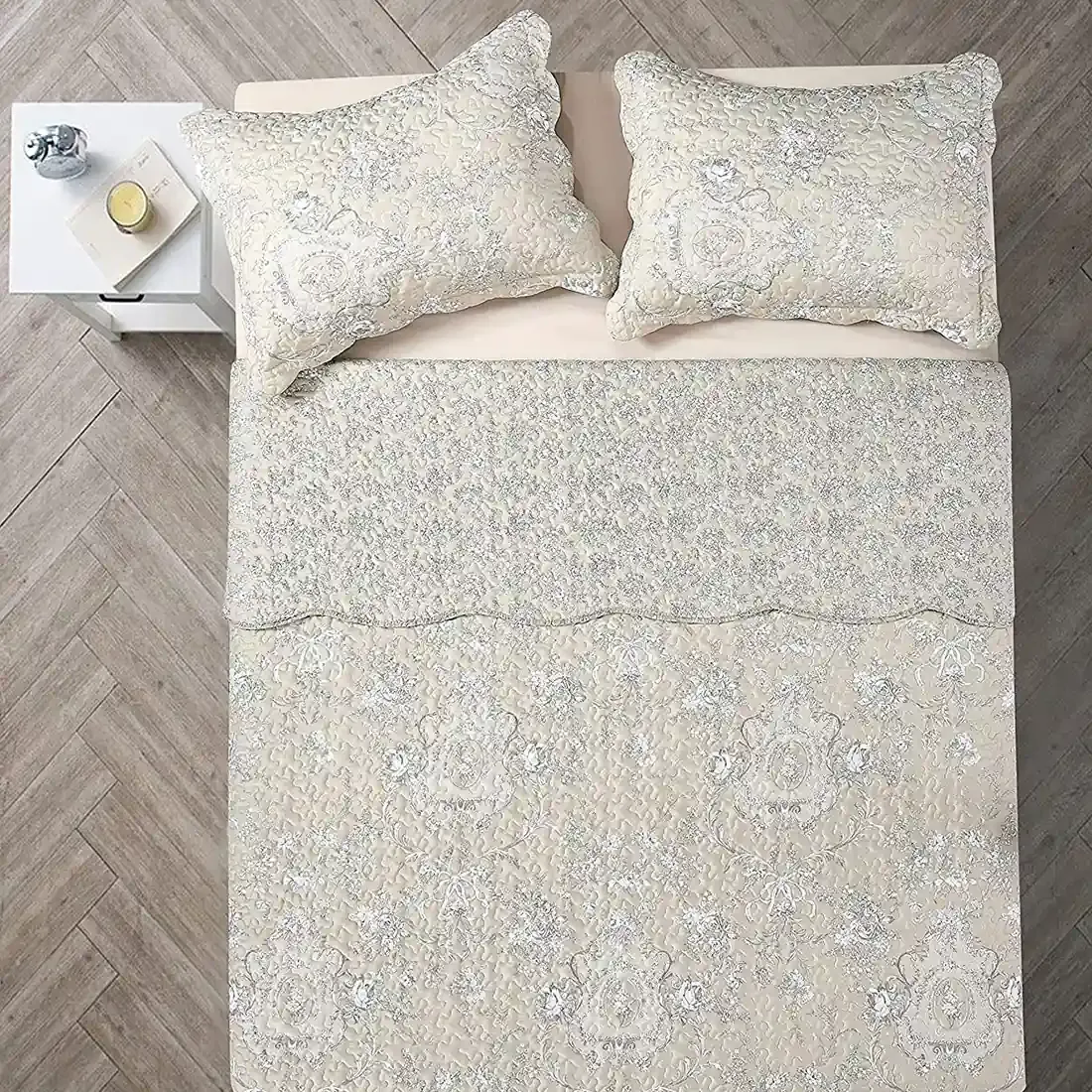 Bovenaanzicht van een beige kussensloop op een bed, aangevuld met een bijpassende Floral Toile sprei.