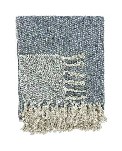 Een gevouwen grijze plaid met visgraatmotief en witte kwastjes.