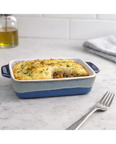 Shepherd's pie served in a reactive glaze oven dish, surrounded by olive oil.