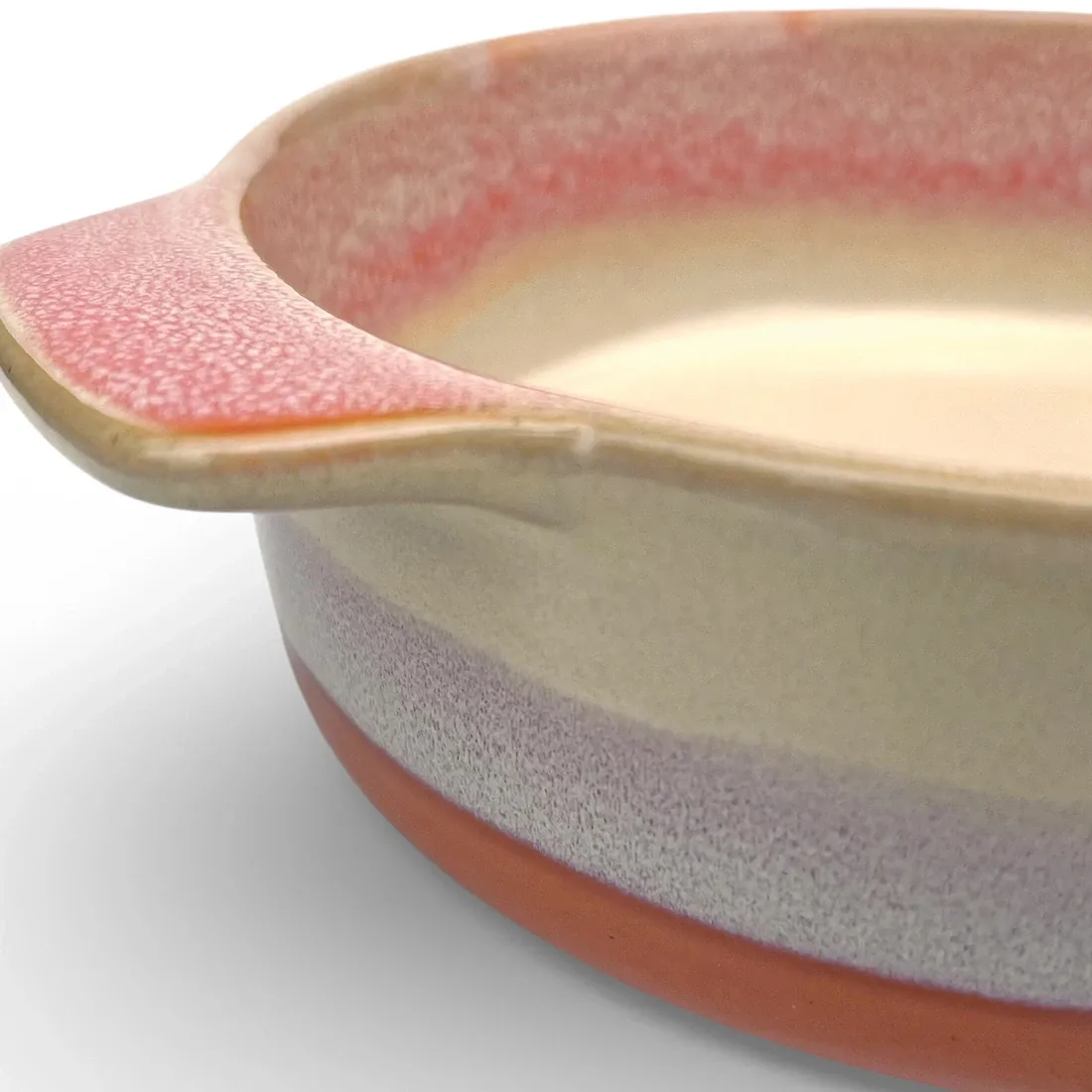 A close-up of a round oven dish high-lighting the reactive glaze finish.