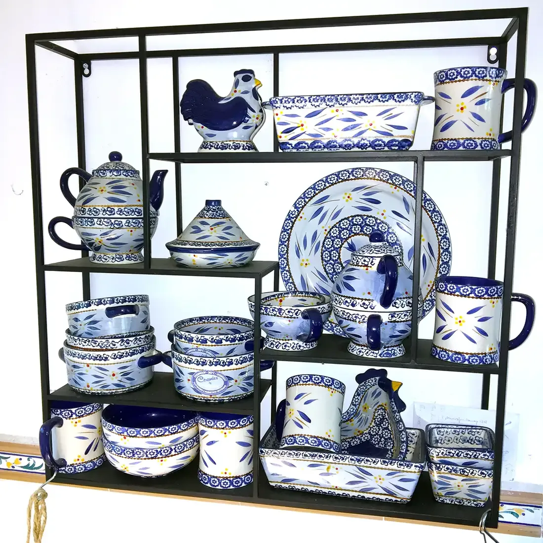 A decorative shelving unit holding a collection of blue and white ceramic tableware.