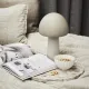 A dessert bowl with nuts sits on a marble tray beside a mushroom lamp.