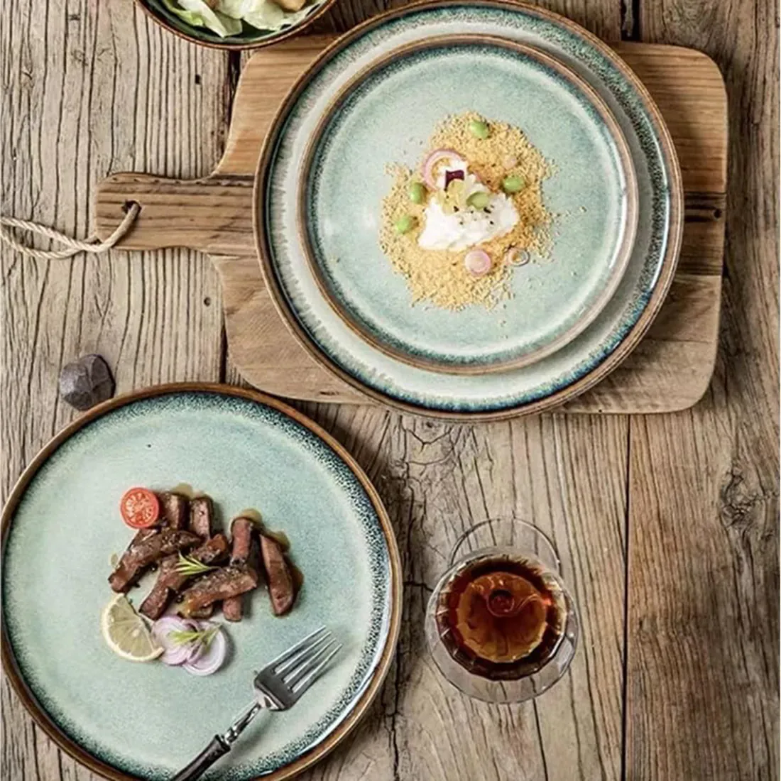 A rustic wooden table features two bohemian dinner plates.