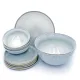 A stack of plates, bowls and a salad bowl, featuring a Nordic grey glaze and contrasting vertical white lines.