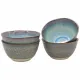 Four ceramic ramen bowls in a gradient of blue and grey, stacked and one tilted to reveal its interior.