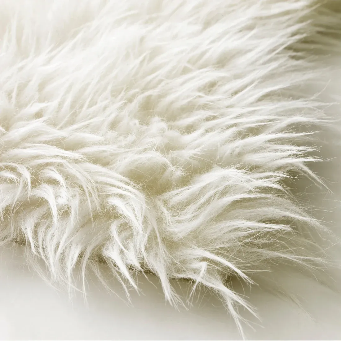 Close-up of a soft, fluffy white faux fur sheepskin rug.