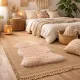 Cosy bohemian bedroom with white bedding, a woven area rug and a beige sheepskin rug.