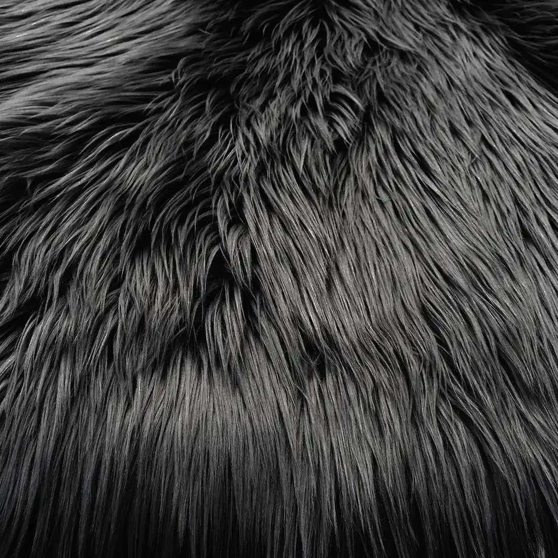Close-up of a soft, fluffy black faux sheepskin rug.