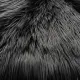 Close-up of a soft, fluffy black faux sheepskin rug.