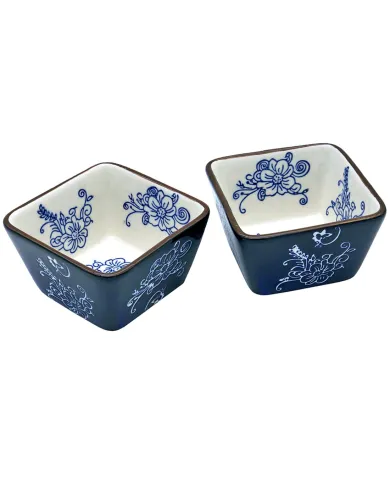 Two square ceramic tapas bowls with blue exteriors and blue floral designs on a white interior.
