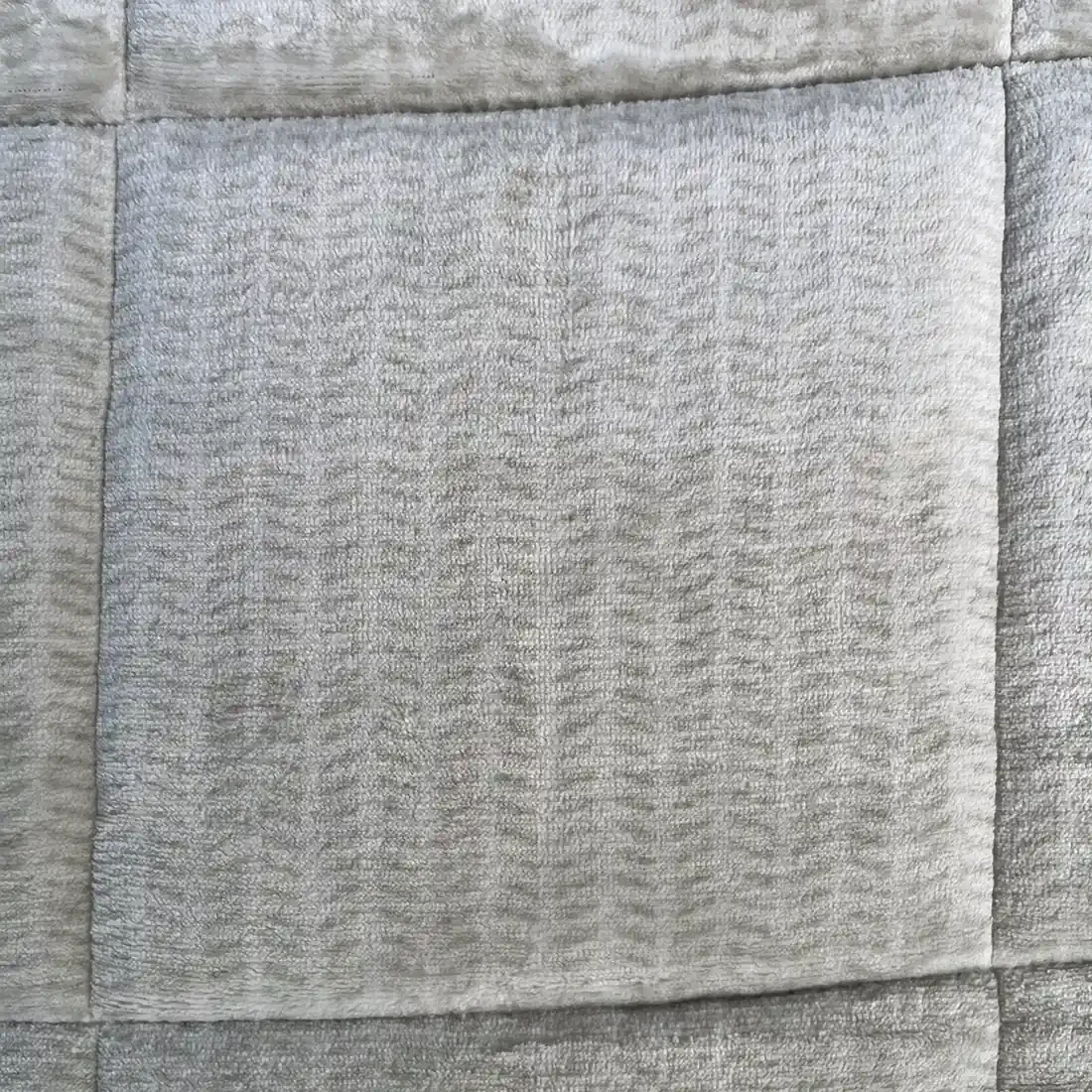 Close-up van een fluwelen dekbed zonder overtrek met de kenmerkende ruitstiksels.