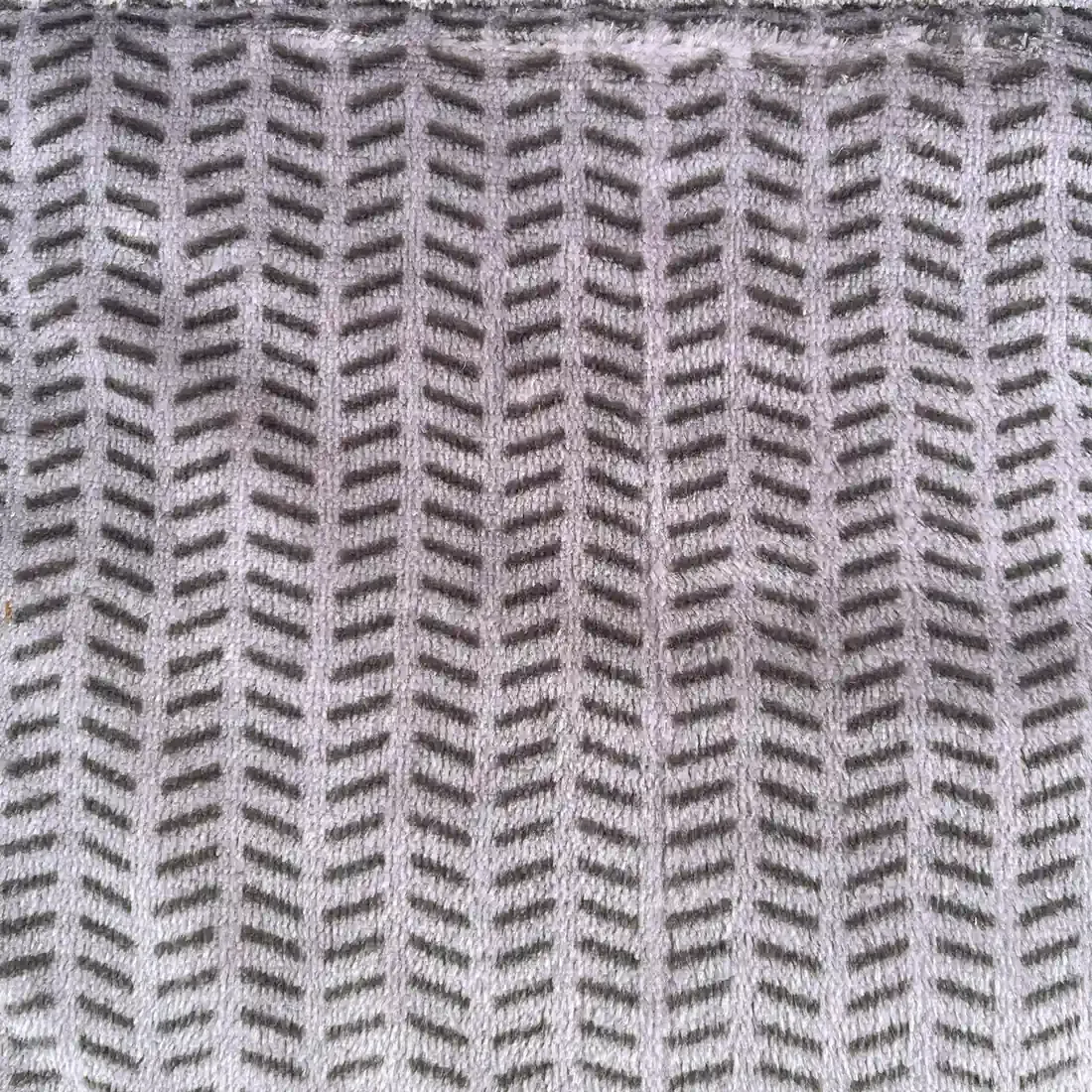 Close-up of a velvet bedspread showcasing the herringbone pattern.